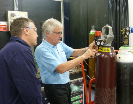 Men inspecting oxy fuel gas cylinders